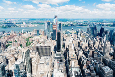 High angle view of modern buildings by sea against sky