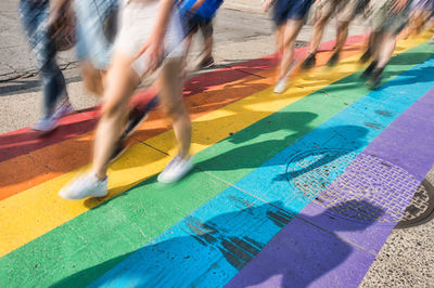 Blurred motion of people walking on colorful street during parade