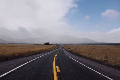 Road passing through landscape against sky