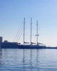 Sailboats sailing in sea against clear blue sky