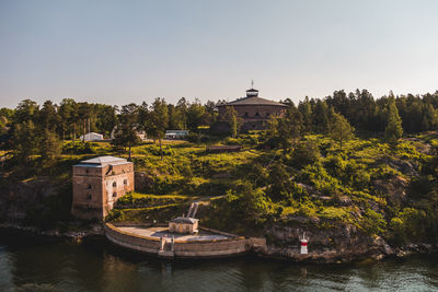 Traditional building by river against clear sky