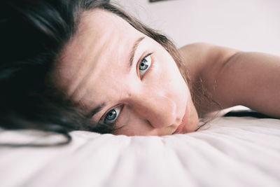 Close-up of woman lying on bed at home