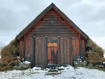 Exterior of building on snow covered field against sky