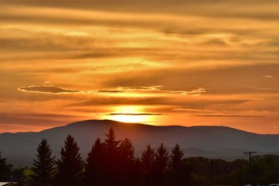 Scenic view of silhouette mountains against orange sky