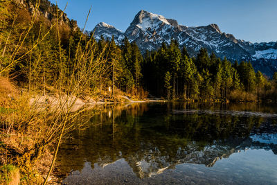 Scenic view of lake by snowcapped mountains against sky