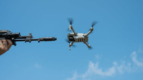 Low angle view of drone flying against clear blue sky