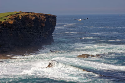 Rock formation in sea against sky