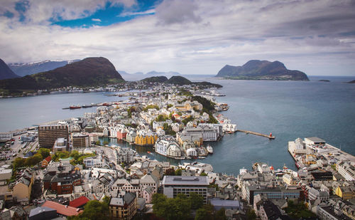 High angle view of city by sea against sky