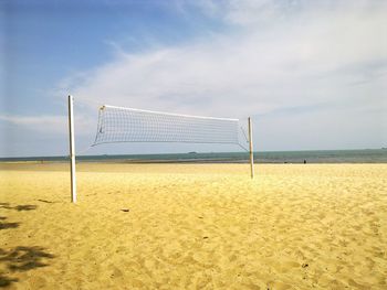 Volleyball net at beach against sky