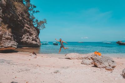 Scenic view of rocks on beach against sky