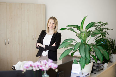 Portrait of young business woman lady wearing white blouse standing in office and looking to camera