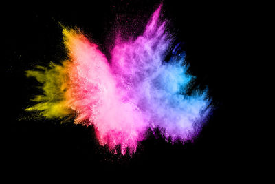 Defocused image of multi colored powder paints against black background