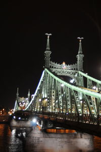 Illuminated suspension bridge against sky at night