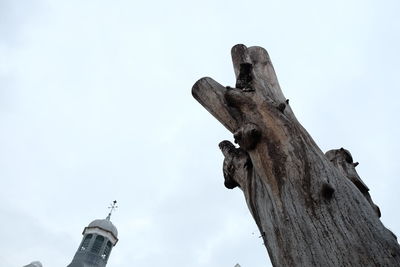 Low angle view of statue against tree against sky