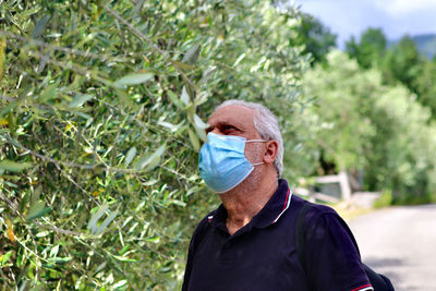 Portrait of man with umbrella against plants
