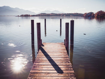 Wooden pier over lake against sky