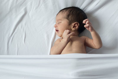 Portrait of cute baby lying on bed