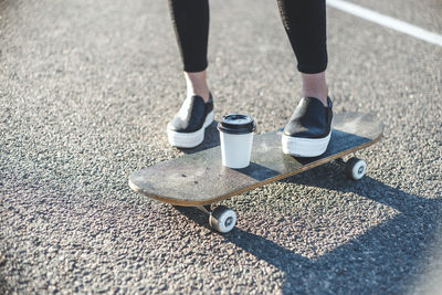 Low section of man skateboarding on road