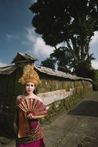 Portrait of woman wearing traditional clothing standing on road