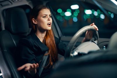 Portrait of young woman sitting in car