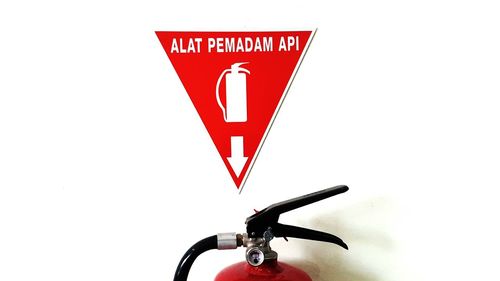 Close-up of red bicycle against white wall