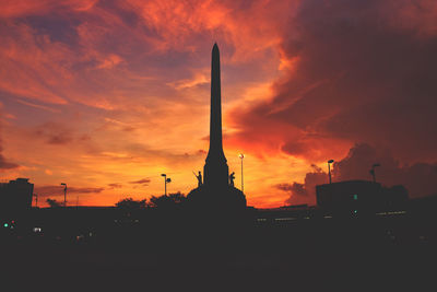 Silhouette monument against orange sky