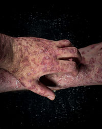 Close-up of hands against black background