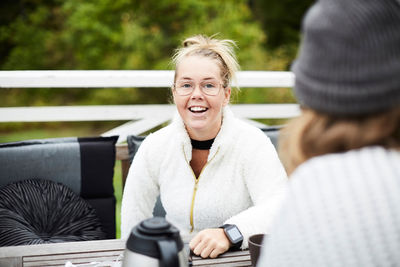 Smiling disabled woman looking at male caretaker sitting at table in backyard
