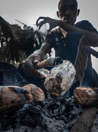 Man cooking food on firewood