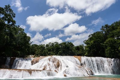 Scenic view of waterfall against sky