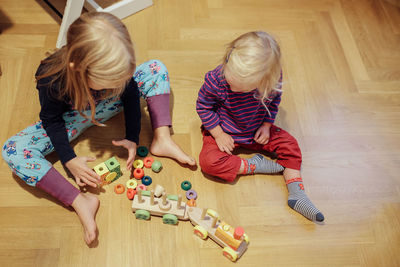 High angle view of girl playing on hardwood floor at home