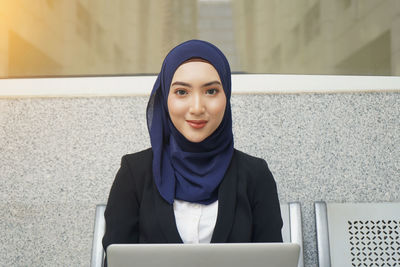 Portrait of smiling young woman using mobile phone