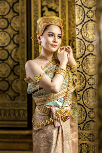 Portrait of a beautiful young woman standing against wall