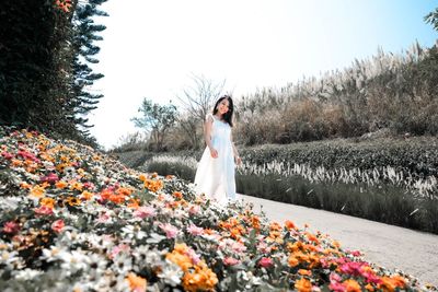 Woman standing by plants against sky