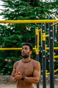 Young man wearing mask exercising outdoors