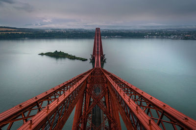 Golden gate bridge over sea against cloudy sky