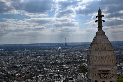 View of cityscape against cloudy sky