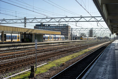 Railroad tracks in city against sky