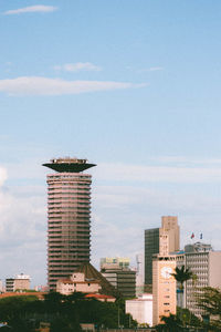 Communication tower in city against sky