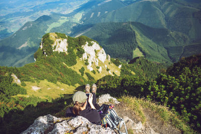 High angle view of woman relaxing on rock at mountain peak