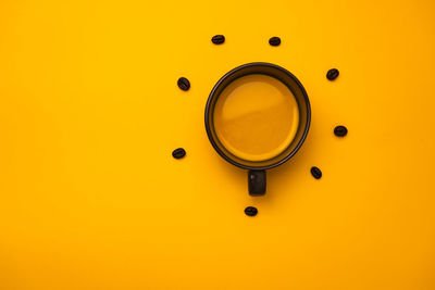 Directly above shot of coffee on yellow background