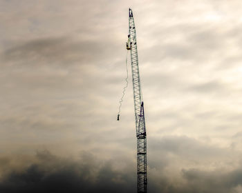 Low angle view of crane against sky