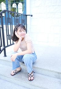 Full length portrait of woman sitting outdoors