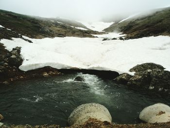 Scenic view of river and mountains against sky