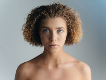 Portrait of young woman against gray background