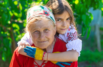 Portrait of senior woman piggybacking granddaughter