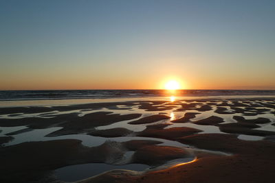 Scenic view of sea against clear sky during sunset