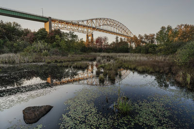 Bridge over marsh of conservation area against sky
