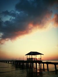 Pier on sea at sunset