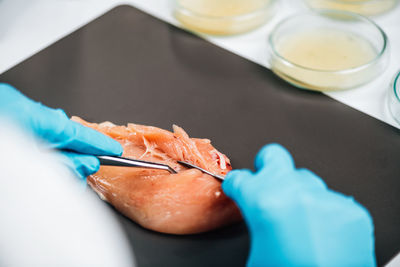 Food safety and quality testing of poultry meat. laboratory technician taking a sample of chicken 